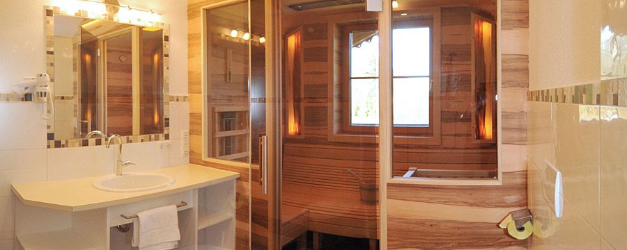 Badezimmer mit Blick in die eigene Sauna in jeder Ferienwohnung